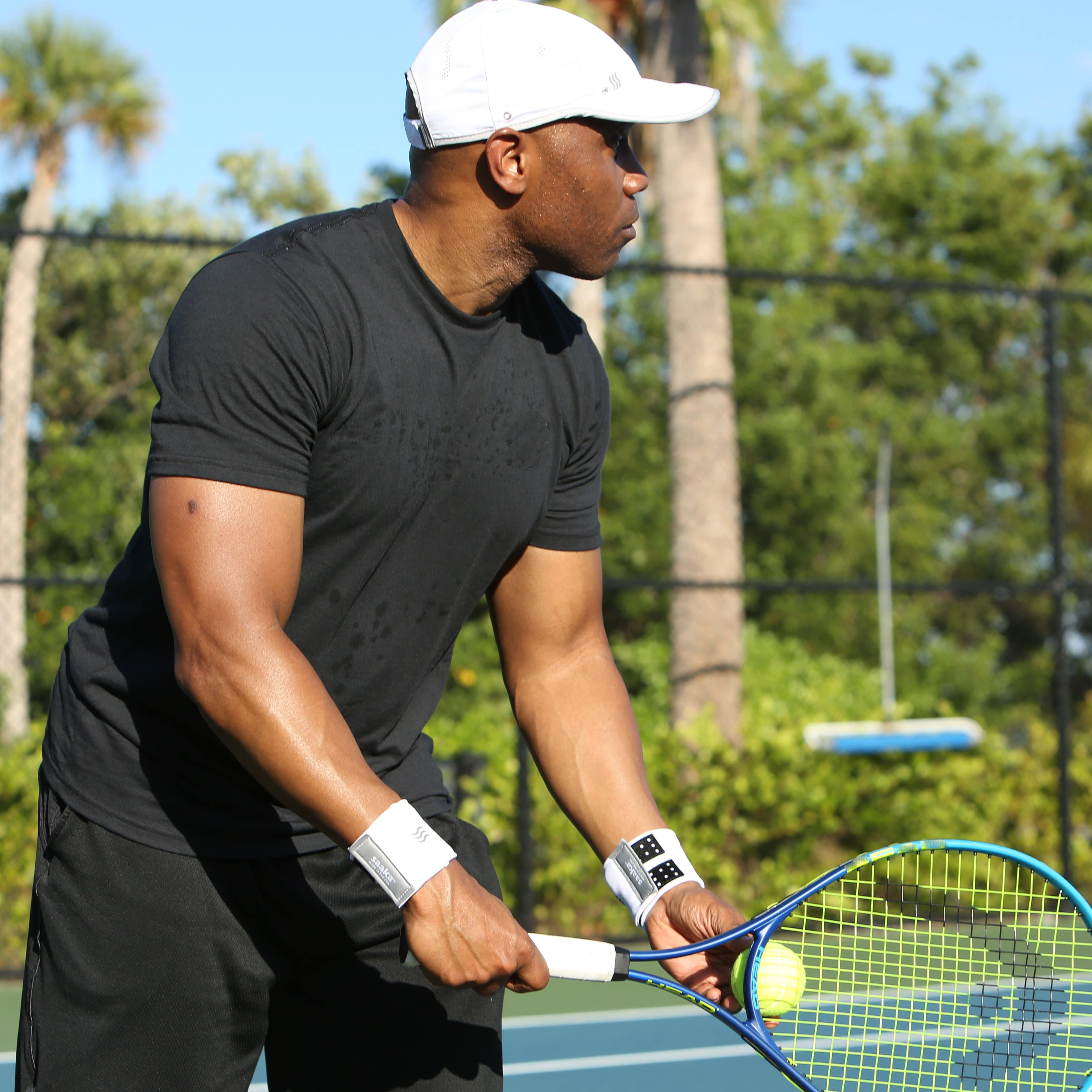 Tennis player wearing two sweat wicking wristbands to help keep his hands dry.
