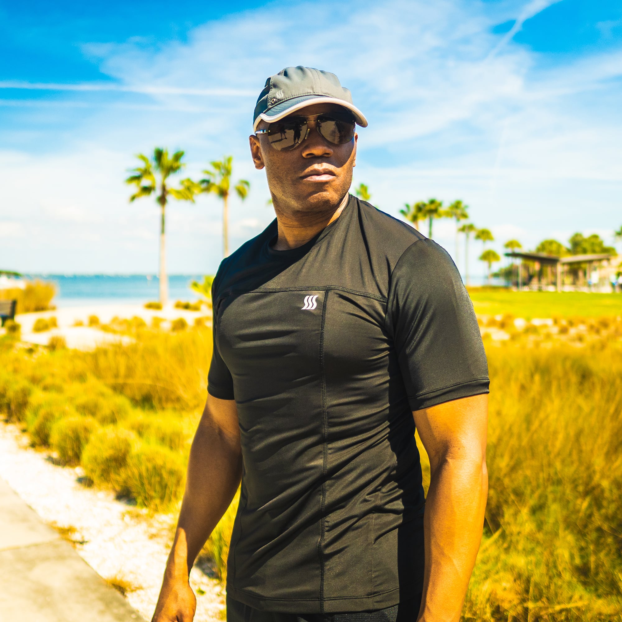 Man wearing a gray sports hat outdoors.